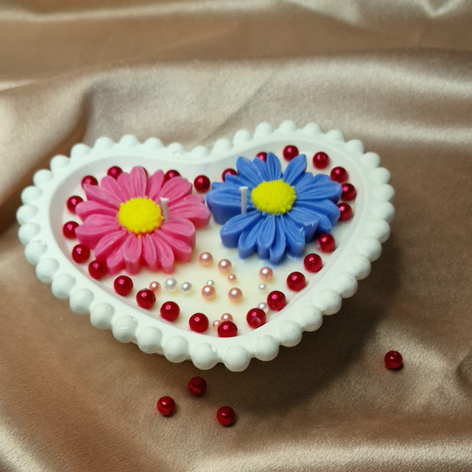 Heart-shaped object with floral designs on a beige fabric background