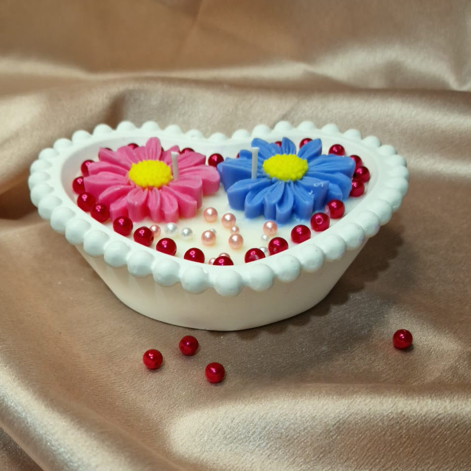 Heart-shaped container with colorful flowers on a beige fabric background