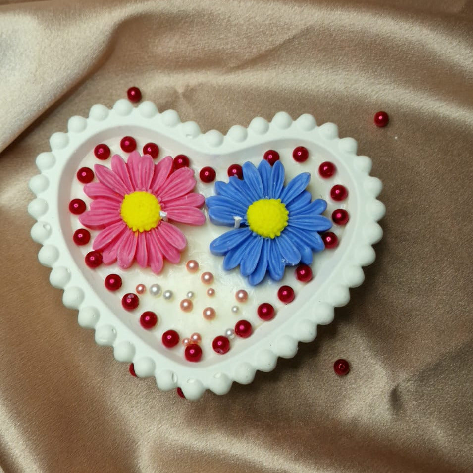 Heart-shaped decorative item with flowers on a brown fabric background